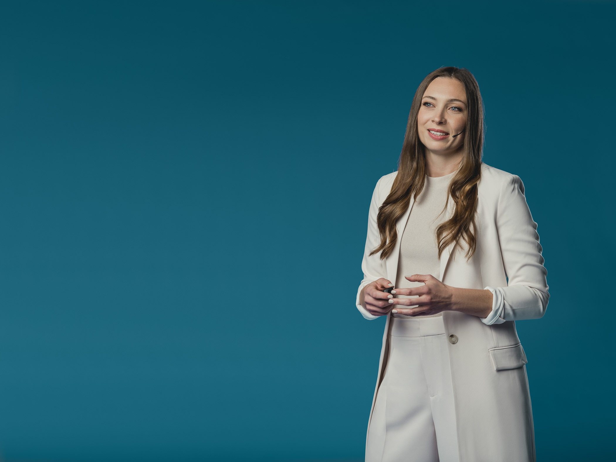 Dr. Jessica Metcalfe speaking, in a cream suit against a teal backdrop